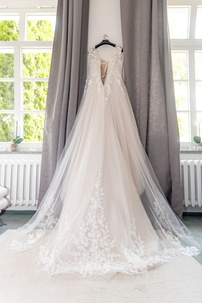 Ein Paar steht an der Spree in Beeskowin Hochzeitskleid auf Schloß Wulkow