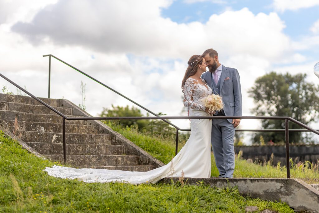 Brautpaar feiert auf Schloß Wulkow und steht verliebt an der Treppe